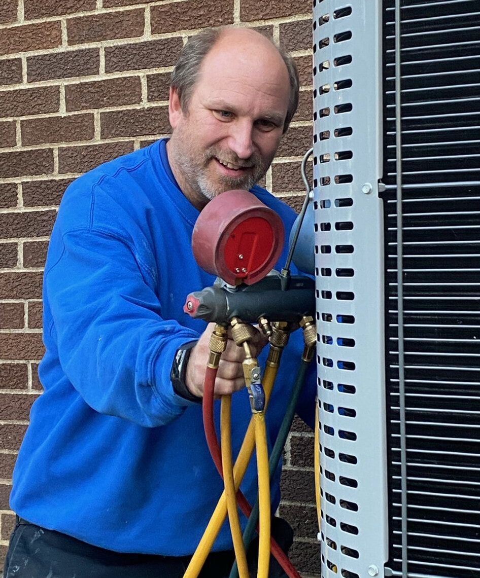 technician using the gauges at the A/C unit
